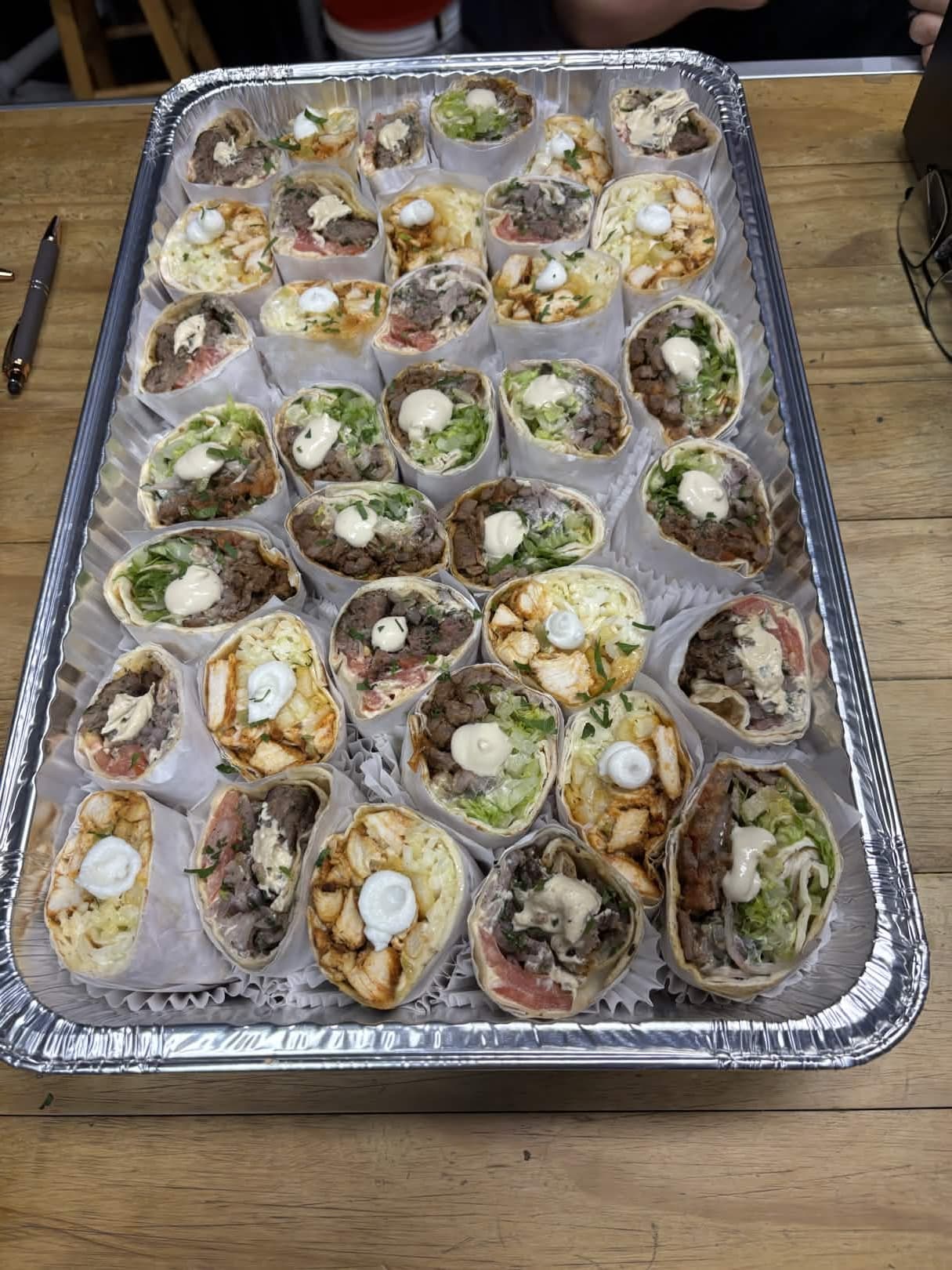 Catering tray of assorted Lebanese wraps with garlic sauce