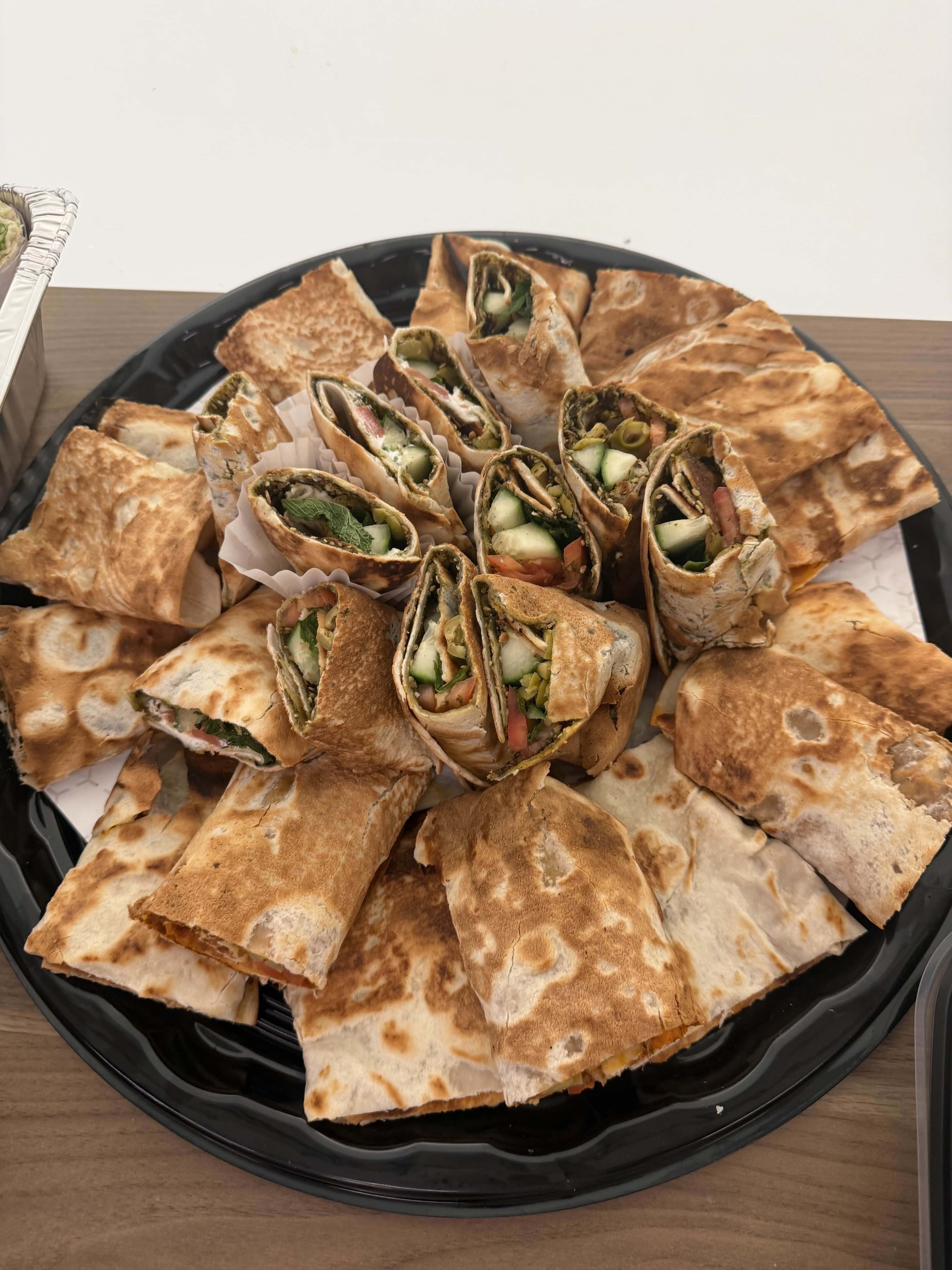 Flatbread wraps with vegetables arranged on a platter for catering