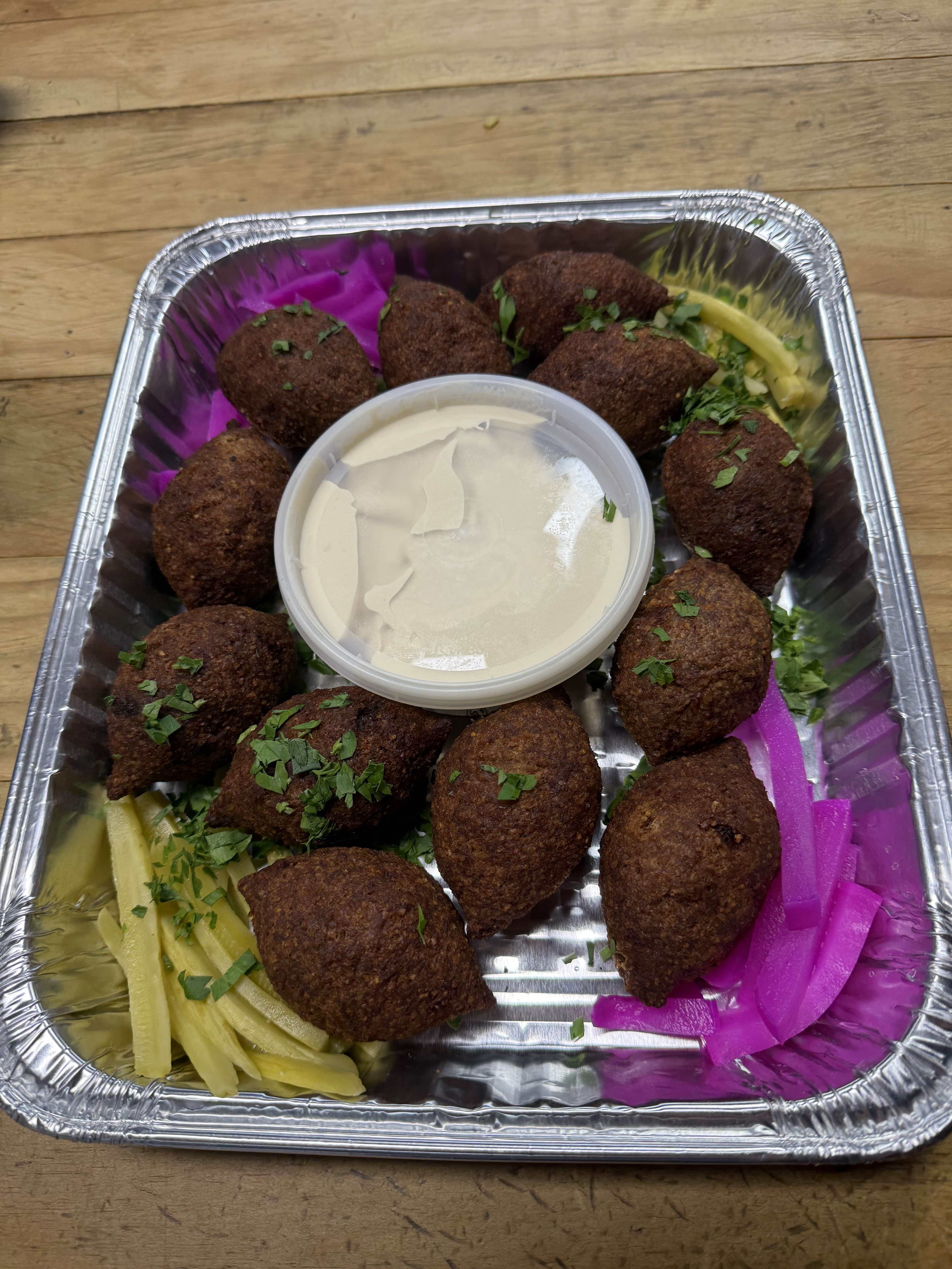 Crispy golden falafel with tahini dipping sauce, pickled turnips, and pickles
