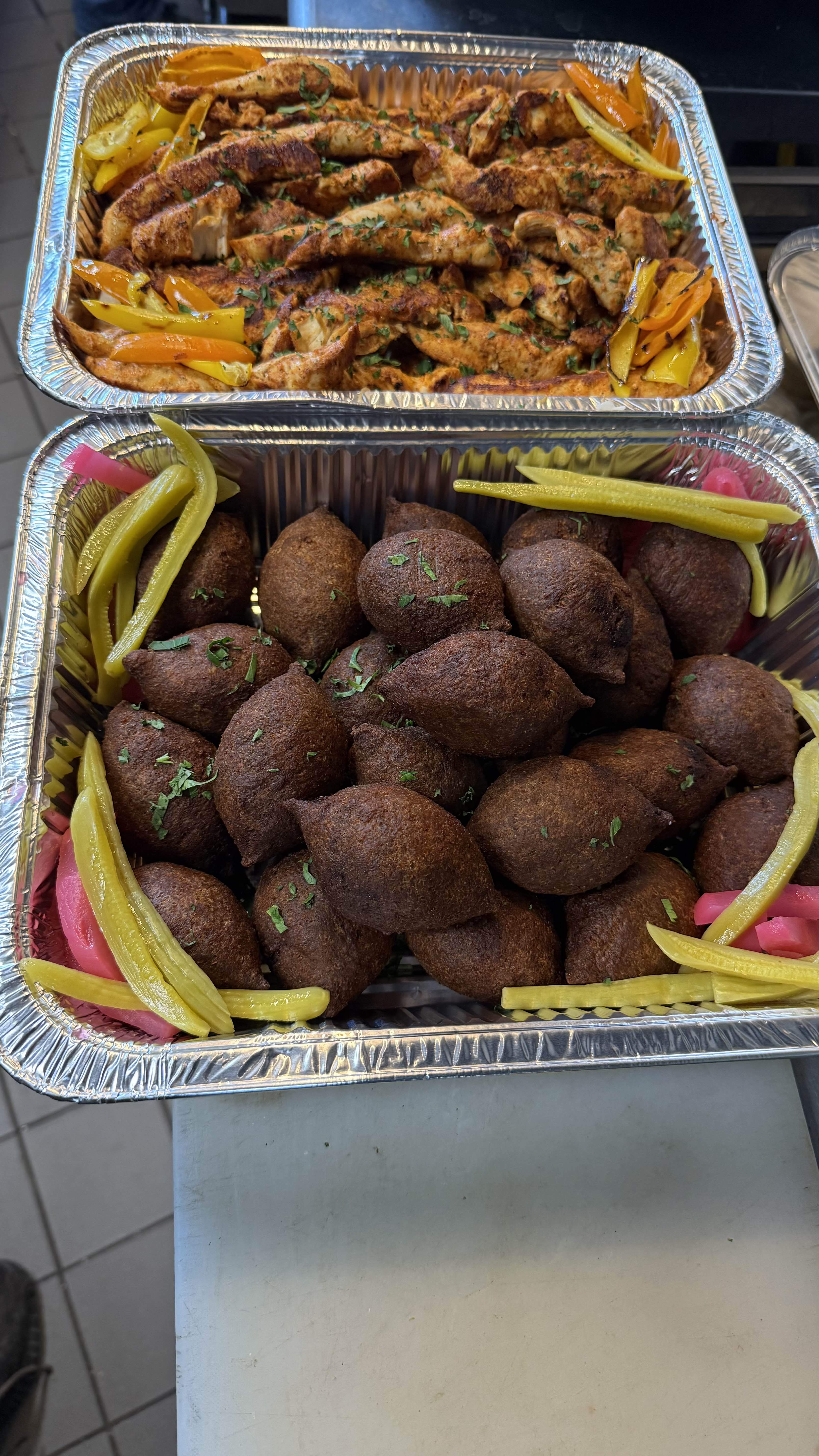 Fried kibbeh and spiced chicken with peppers ready for catering